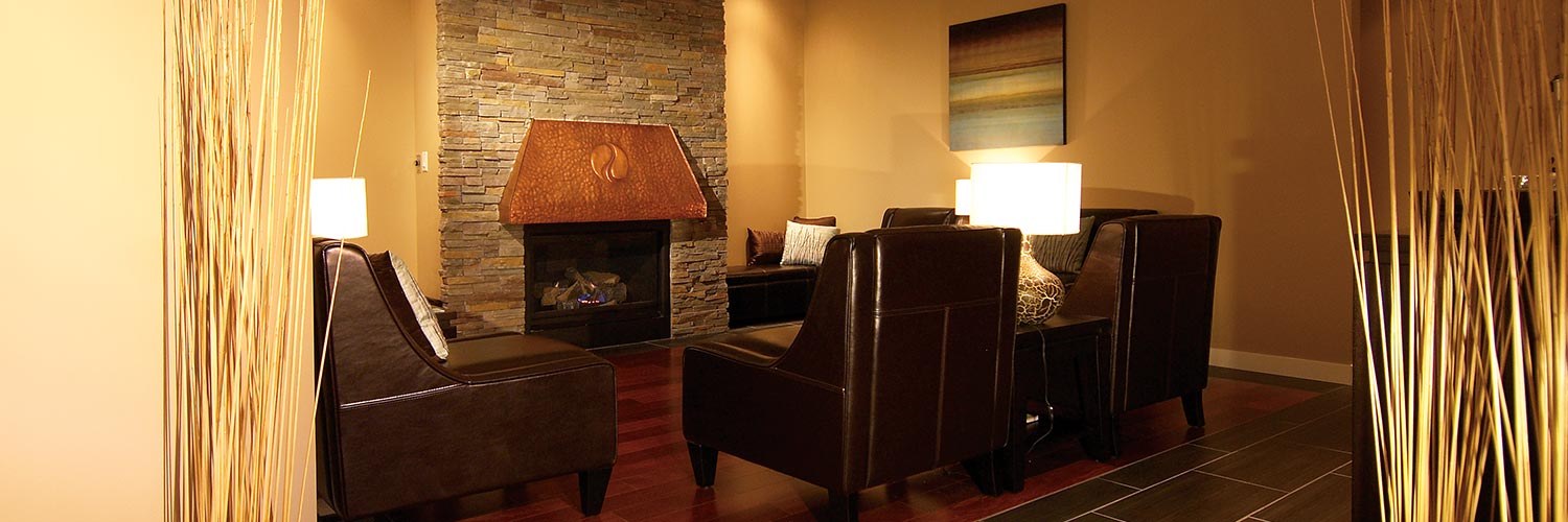 The relaxation lounge at The Waters, with a stone fireplace and leather chairs