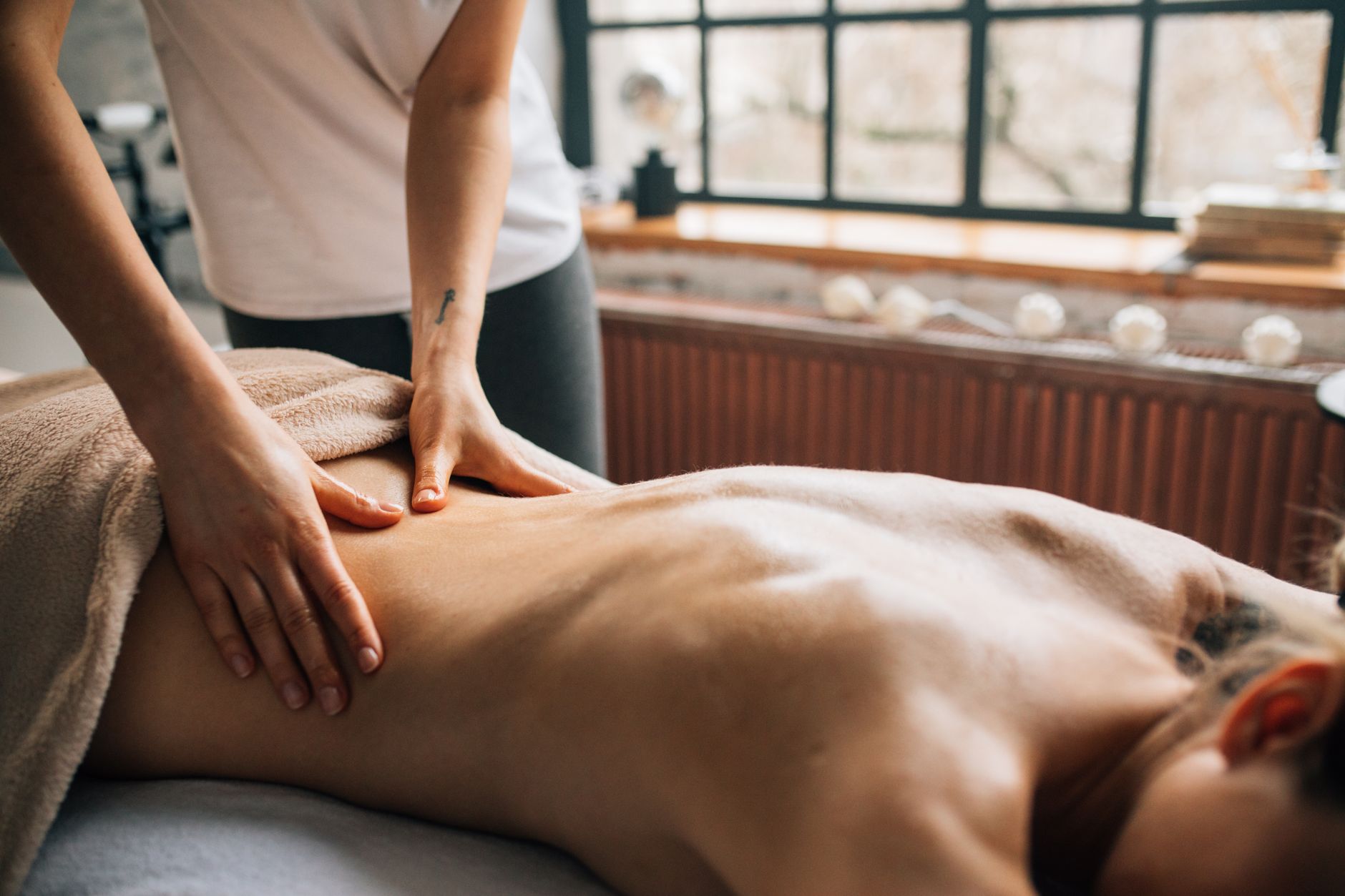 A massage therapist working in a calm, dimly lit room